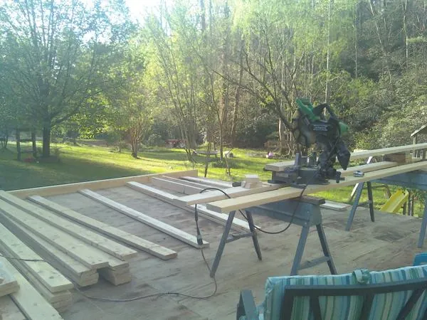 Miter saw and framing lumber on a deck under construction in Vinton